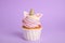 Cute sweet unicorn cupcake on violet background