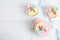 Cute sweet unicorn cupcakes on white wooden table, flat lay. Space for text