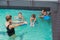 Cute swimming class in pool with coach