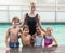 Cute swimming class in pool with coach