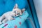 Cute tabby kitten with blue eyes lying on the pillow on the blue background