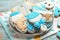 Cute tasty cookies of different shapes on light blue wooden table, closeup. Baby shower party