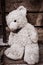 Cute teddy bear abandoned near old wooden