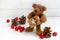 Cute teddy bear with a Christmas gift, cones and red balls on a