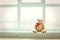 Cute teddy bear at home in white room is sitting near window. Alone bear waiting for a baby boy or girl.