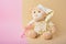 Cute teddy bear and pink baby glasses on beige and pink background