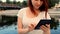 Cute teen age girl with ginger hair using her tablet outside near river. Outdoors lifestyle portrait.