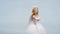 Cute teen cupid on the cloud - sky background. Angel child girl with curly blonde hair. Pretty white little girl as the