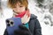 Cute teen girl having fun on a walk in snow covered pine forest on chilly winter day. Teenage child exploring nature