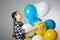 Cute teen girl holding a bunch of colorful balloons