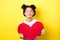 Cute teenage asian girl dreaming of true love, close eyes and showing big red heart cutout, waiting for soulmate on