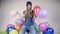 Cute teenage girl with balloons in bright studio.