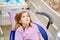 Cute teenage girl in the dental chair is afraid to treat her teeth.