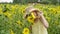 Cute teenage girl in hat posing between sunflowers