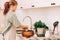 Cute teenage girl in kitchen apron prepares and kneads products for making dough for baking