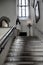 Cute teenage girl with long brunette hair and white dress on a grand old fashioned staircase