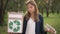 Cute teenage girl looking at box with recycle sign and plastic bottle smiling looking at camera. Portrait of pretty