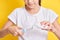 cute teenage girl with pigtails hairstyle squeezes toothpaste on an electric toothbrush, yellow background