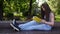 Cute teenage girl reading book sitting on the bench in park, studying outdoor. HD video footage shooting of static