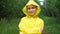 Cute teenage girl in yellow raincoat looks in camera smiling