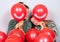 Cute teenage girls peeking behind smiling balloons