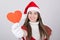 Cute teenage Santa girl showing red heart