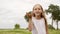 Cute teenager girl blowing daisy petals from palm hand to camera. Carefree young girl blowing flower petals from hands