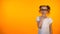 Cute thoughtful preteen girl planning education isolated on orange background