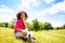 Cute timid little girl with football ball on grass