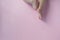 Cute tiny chubby newborn baby legs on light-pink background