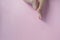 Cute tiny chubby newborn baby legs on light-pink background. Copy space available