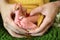 Cute tiny Saudi newborn baby girl feet closeup rings in thumbs female holding hands