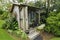 Cute tiny timber antique shack sitting in stunning flower garden