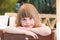 Cute tired Caucasian little girl, close-up outdoor