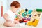 Cute toddler baby playing with busy board at home