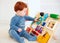 Cute toddler baby playing with busy board at home