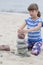 Cute toddler on the beach playing with stones