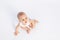Cute toddler boy 8 months old in white bodysuit sits on white background, looking at the top, space for text