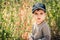 Cute toddler boy in black baseball cap and amber necklace on his neck outdoor