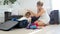 Cute toddler boy helping his mother packing thing for summer beach vacation