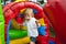 Cute toddler boy jumping on a inflatable bouncer in a backyard on warm and sunny summer day. Sports and exercises for children