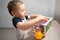 A cute toddler boy is playing a game with sensory colorful balls. Sensory and tactile activities. Games for children one and a