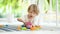 Cute toddler boy playing with lego blocks construction set on the floor at home