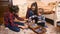 Cute toddler boy playing with toys with his elder sisters