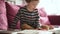 Cute toddler boy reading books on the sofa at home on a bright sunny afternoon