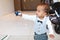 Cute toddler boy in suit with bowtie holding toy care