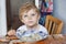 Cute toddler boy of three years eating pasta at home kitchen