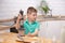 Cute toddler boy using hand blender to make minced meat. Preparing meal in the kitchen