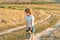 Cute toddler boy working on farm outdoors. Child farmer in the farm with harvest at countryside background. Crop