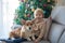 Cute toddler child. boy, hugginh baby puppy corgi dog at home on Christmas